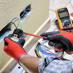 electrician performing outlet maintenance repair
