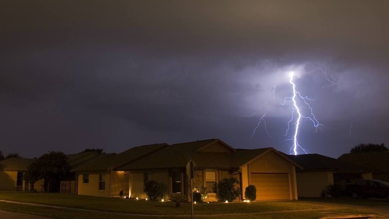 Lightning strikes in the night near residential area