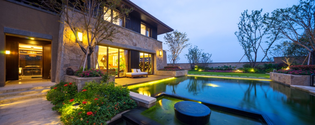 exterior of a modern style house with lights around house and pool